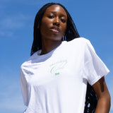 Model wearing Touch Grass Club t-shirt against blue sky