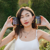 Lifestyle image of model holding HUA Wellness Whole Food Magnesium Powder Supplment for Sleep, Relaxation, Muscle Recovery, and more in both Mixed Berry and Lemon flavors. Experience the benefits of magnesium with this premium powder supplement.