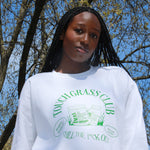 Photo of model wearing Touch Grass Club sweatshirt with tree background