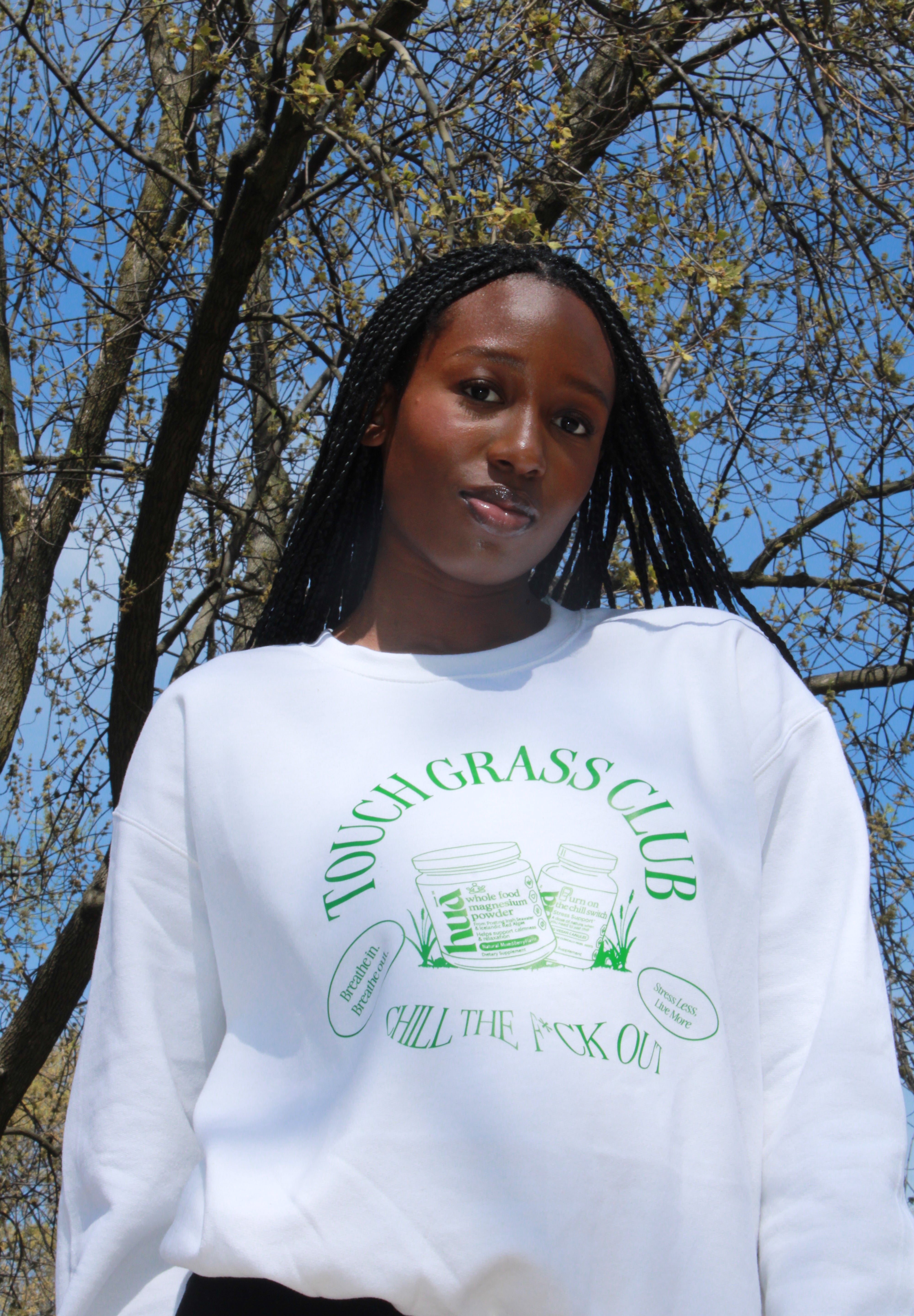 Photo of model wearing Touch Grass Club sweatshirt with tree background